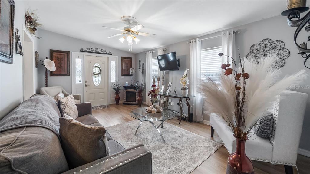 A living room features a grey sofa, glass coffee table, and a white front door — 251 PATTERSON ROAD UNIT A27, HAINES CITY, FL
