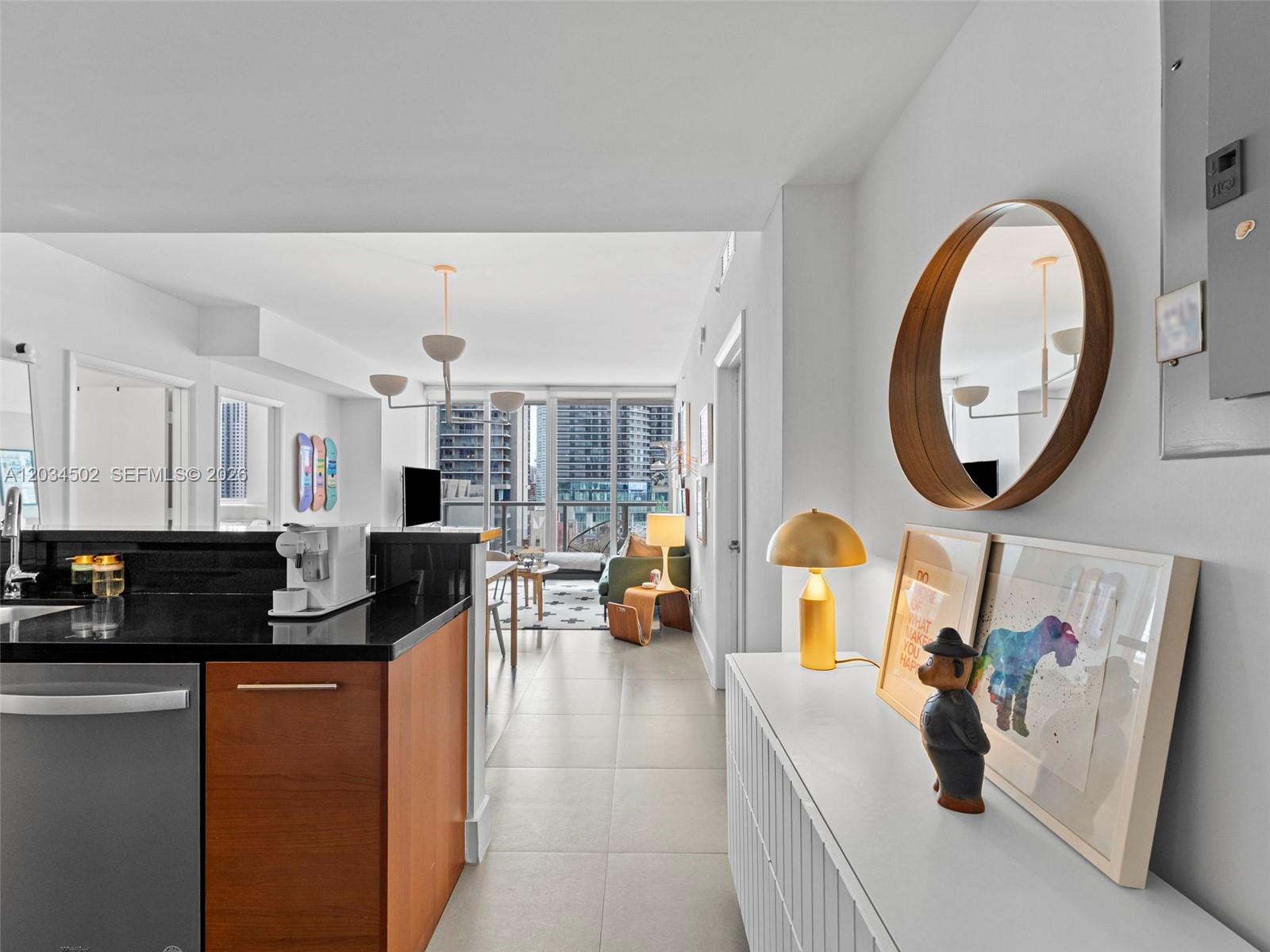 A modern apartment interior features a kitchen counter, a hallway with decor, and a living area — 253 NE 2nd St # 1801, Miami FL 33132, MIAMI, FL