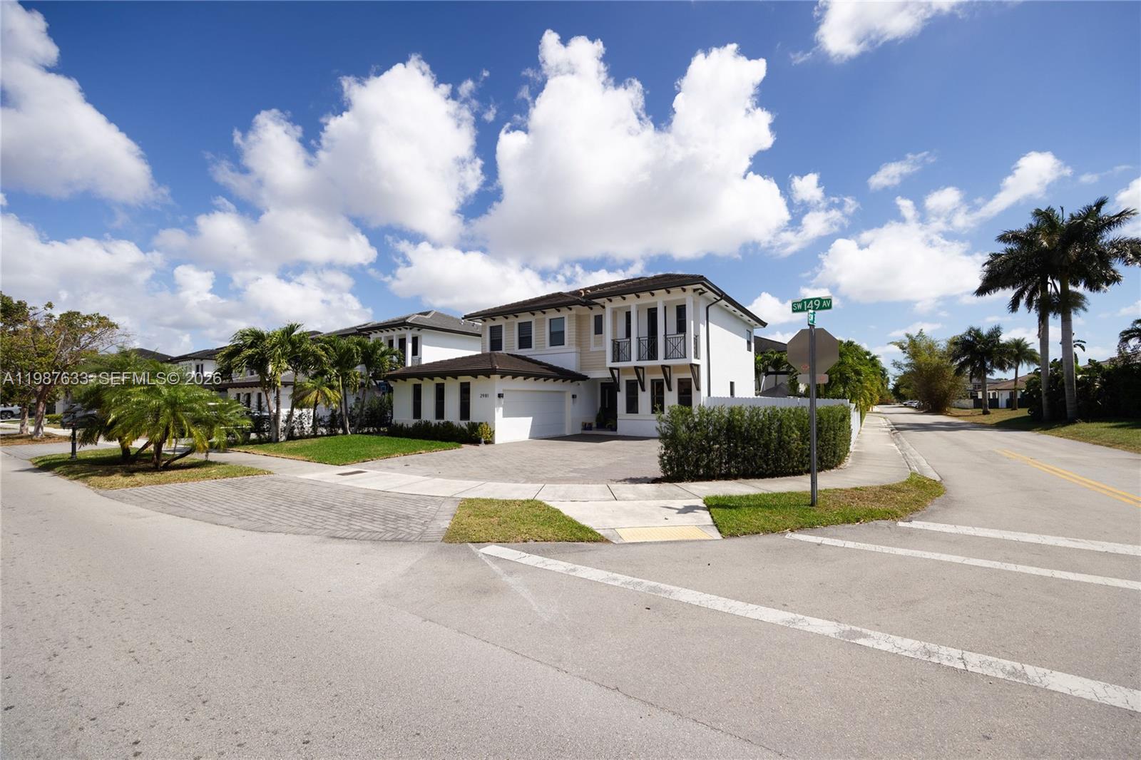 A two-story white house with a garage and palm trees sits on a corner lot — 2981 SW 149th Ave, Miami FL 33185, MIAMI, FL