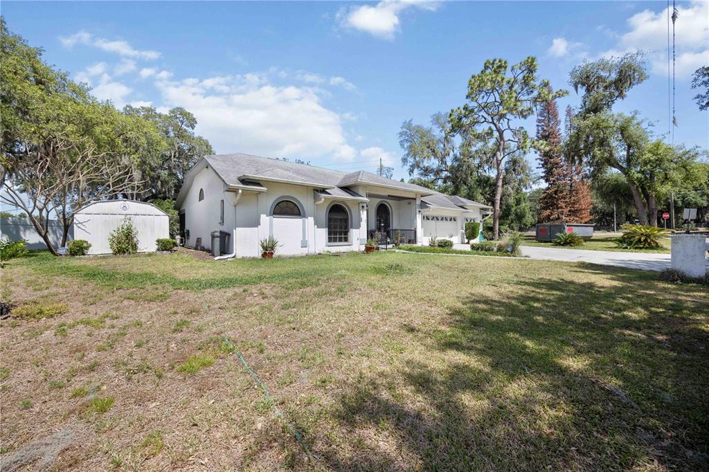 A single-story white house with a metal shed and a large front yard — 5235 POST LANE, LAKELAND, FL