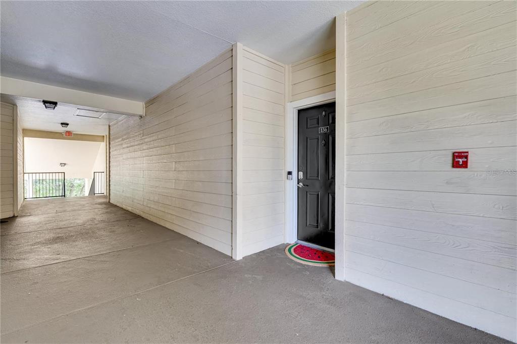 A black front door with the number 136 is set in a light-colored exterior hallway — 2632 ROBERT TRENT JONES DRIVE UNIT 136, ORLANDO, FL