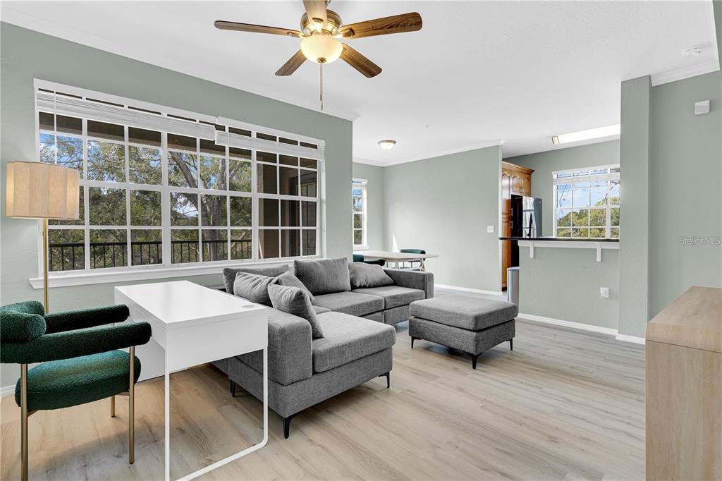 A living room features a gray sectional sofa, a white desk, and a ceiling fan — 2632 ROBERT TRENT JONES DRIVE UNIT 136, ORLANDO, FL
