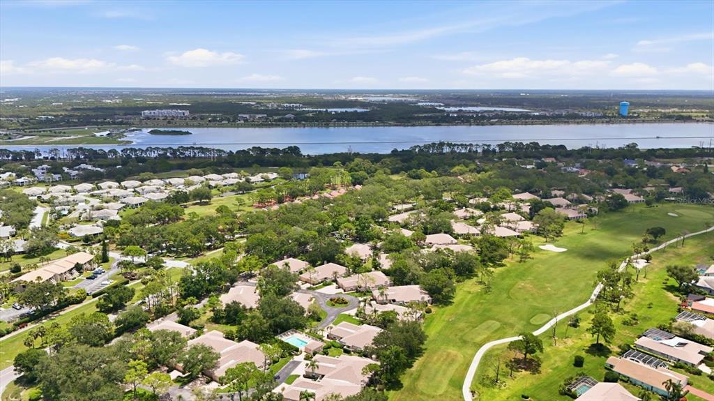 Aerial view of a residential community with houses, a golf course, and a large lake — 5435 CHANTECLAIRE UNIT 69, SARASOTA, FL