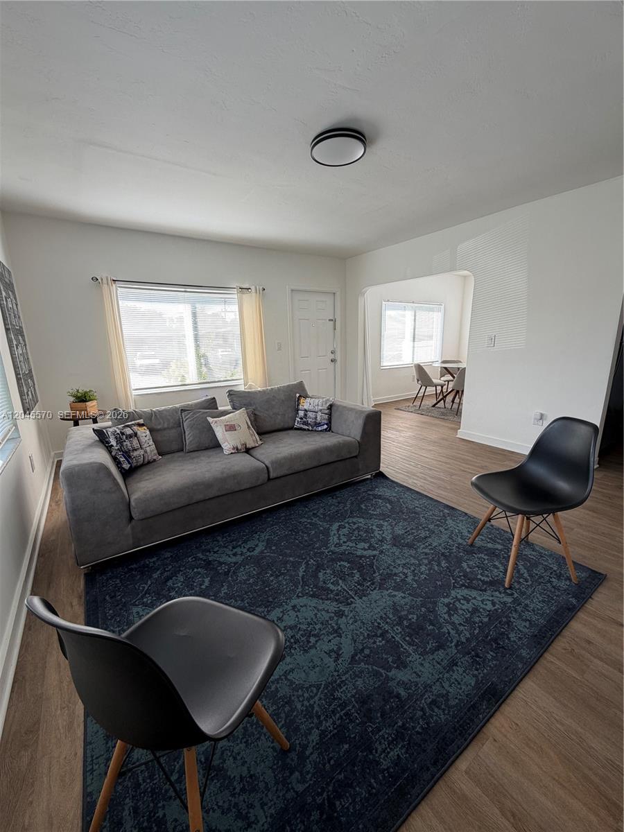 A living room features a gray sofa, two black chairs, and a dark patterned rug — 1215 NE 109th St # 1215, Miami FL 33161, MIAMI, FL