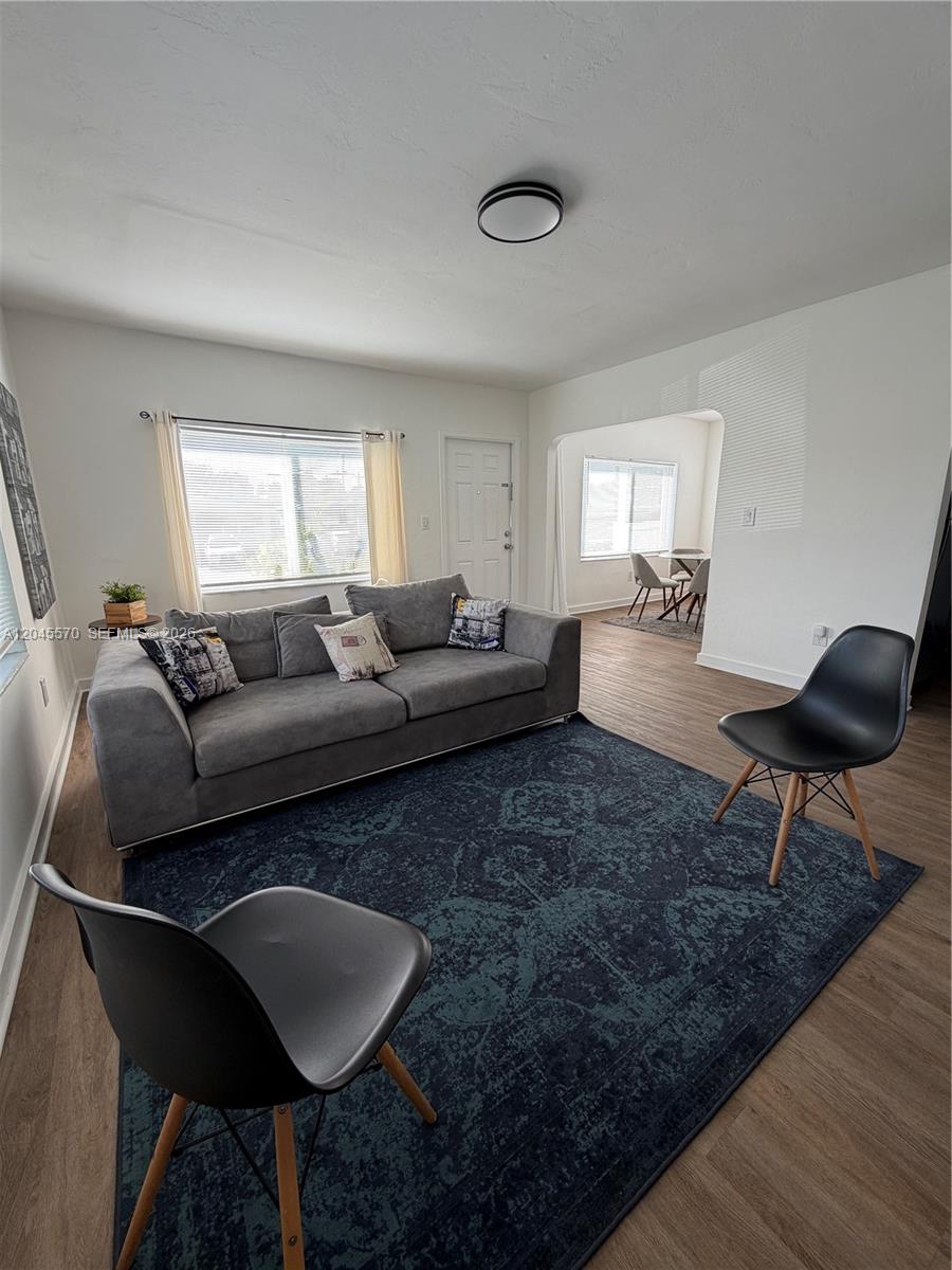 A living room features a gray sofa, two black chairs, and a dark patterned rug — 1215 NE 109th St # 1215, Miami FL 33161, MIAMI, FL