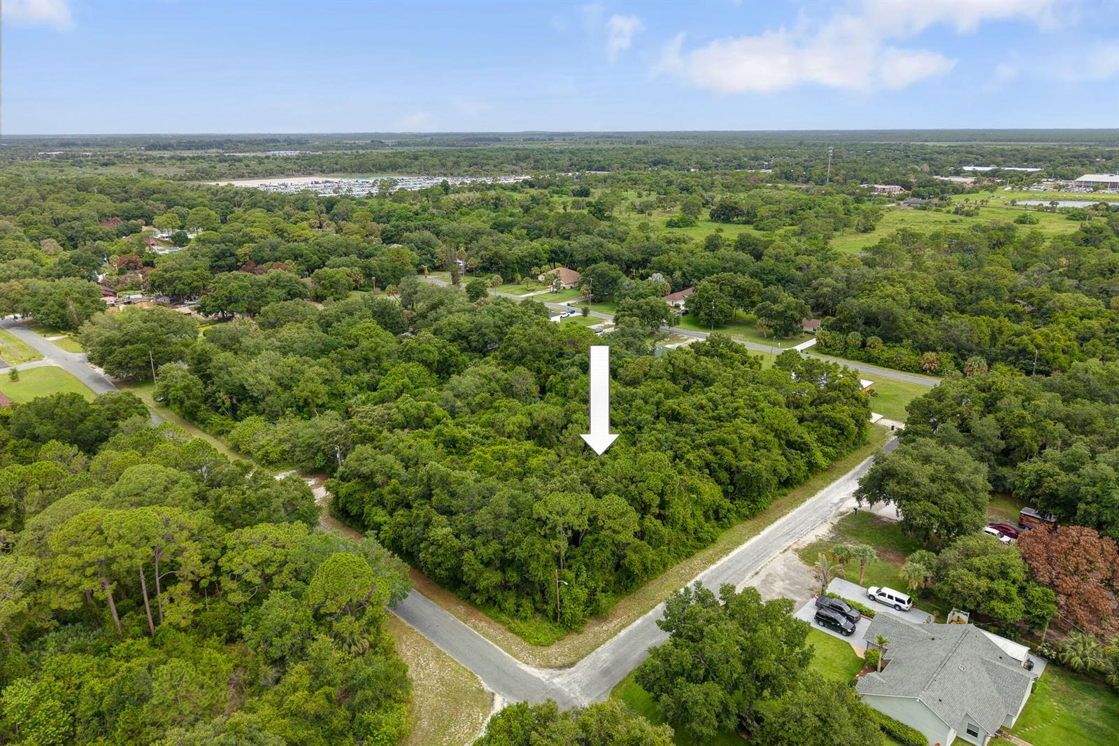 An aerial view shows a wooded, undeveloped corner lot marked by a white arrow — 47 N St, Fort Pierce FL 34946, FORT PIERCE, FL
