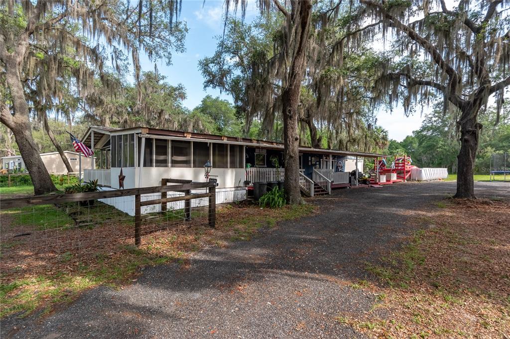 A gravel driveway leads to a single-story home surrounded by trees with hanging Spanish moss — 134 FAYE STREET, HAWTHORNE, FL