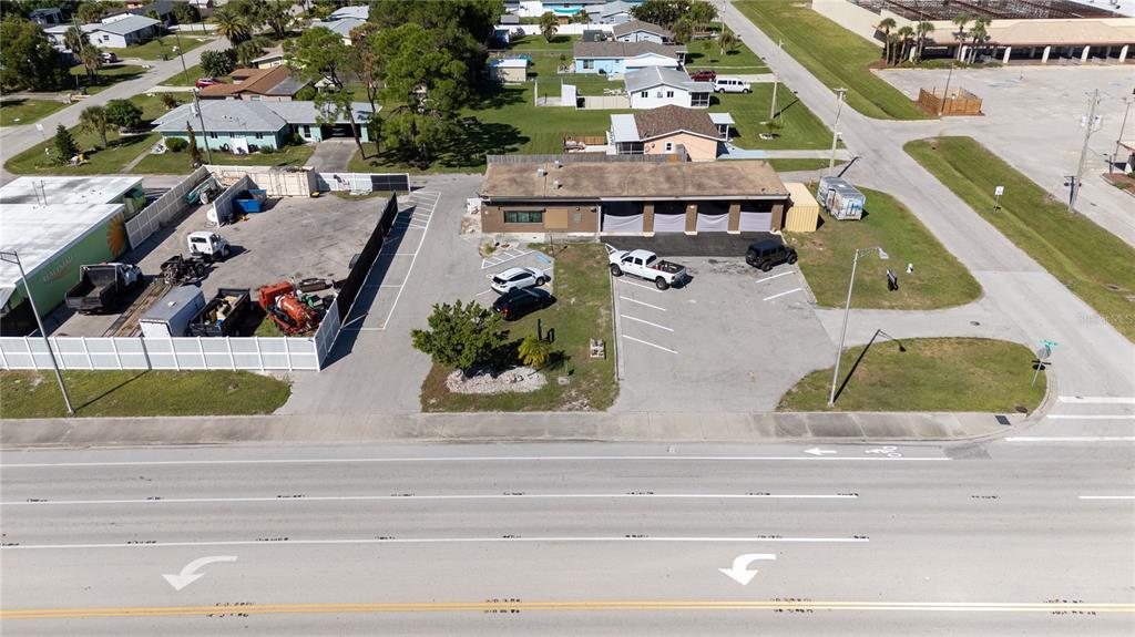 An aerial view shows a commercial building with a parking lot next to a road — 334 S INDIANA AVENUE, ENGLEWOOD, FL