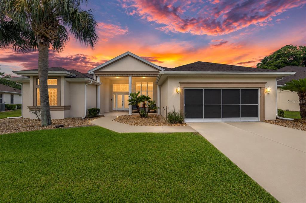 A single-story house with a beige exterior, a two-car garage, and a palm tree — 6577 SW 111TH LOOP, OCALA, FL