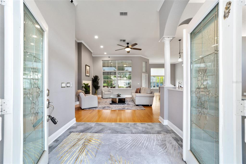 A view from an open front door into a living room with hardwood floors — 6577 SW 111TH LOOP, OCALA, FL