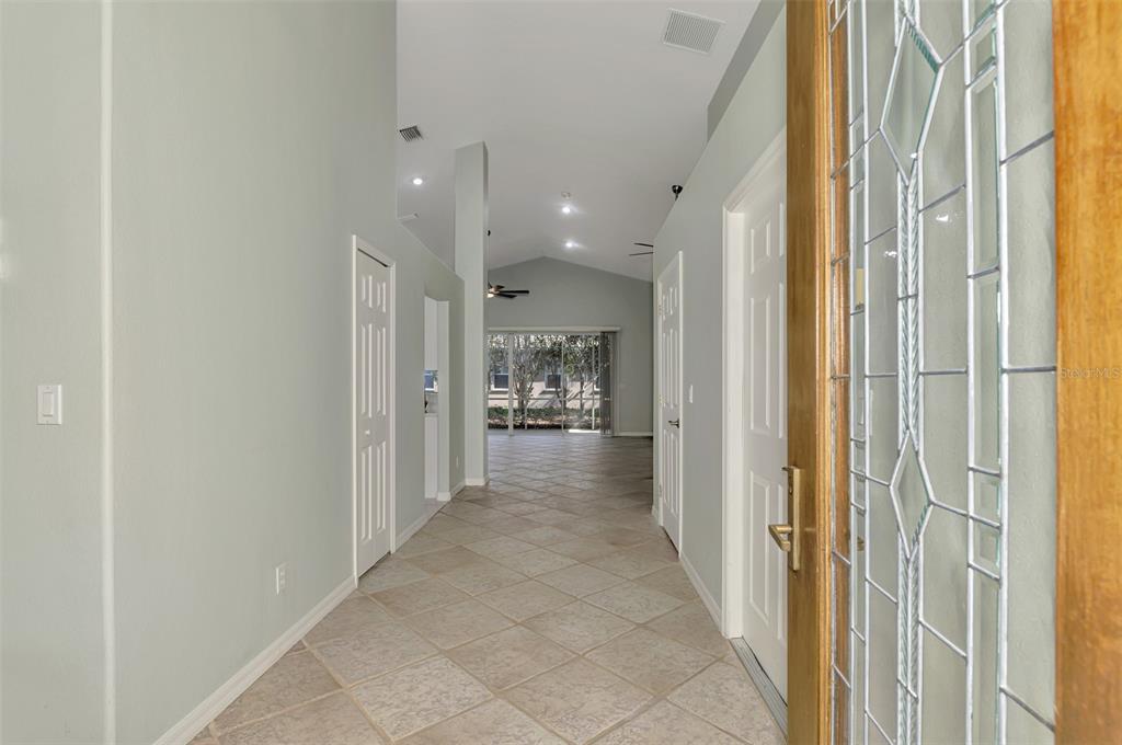 An entryway with tiled floors leads to a living area with a vaulted ceiling — 5271 HIGHBURY CIRCLE, SARASOTA, FL