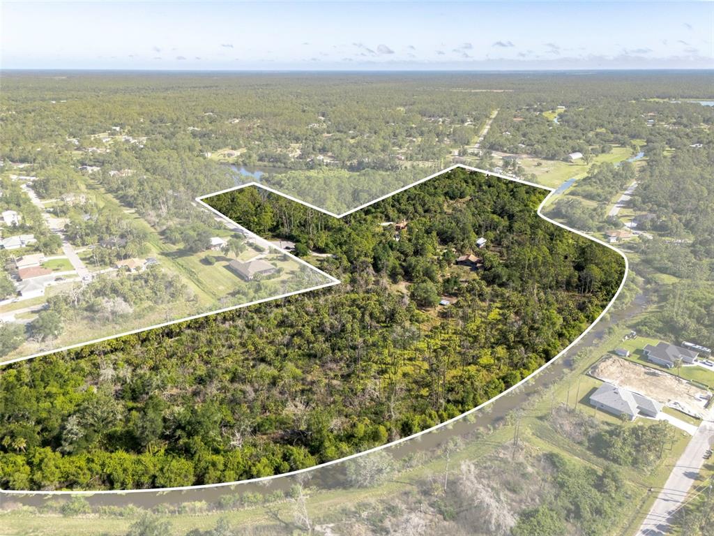 An aerial view shows a large, wooded parcel of land outlined in white — 3000 NARCISSUS TERRACE, NORTH PORT, FL