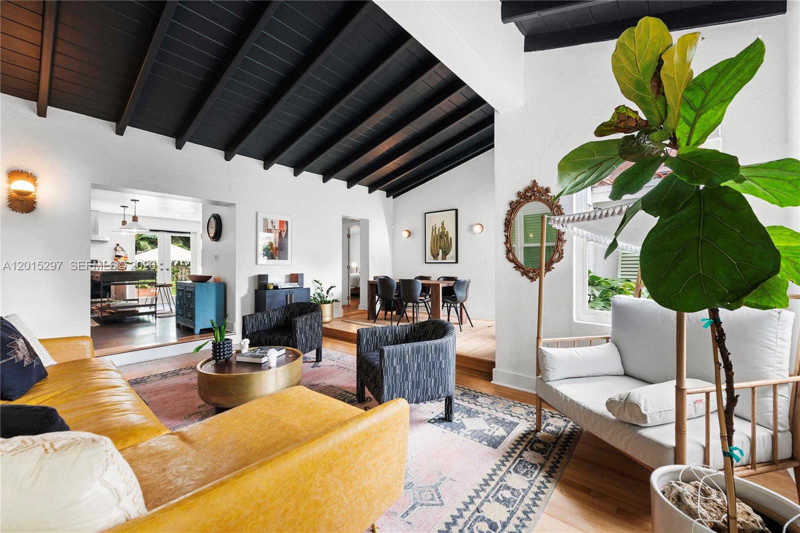 A living room features a black vaulted ceiling, yellow sofa, and an adjacent dining area — 723 NE 112th St, Biscayne Park FL 33161, BISCAYNE PARK, FL