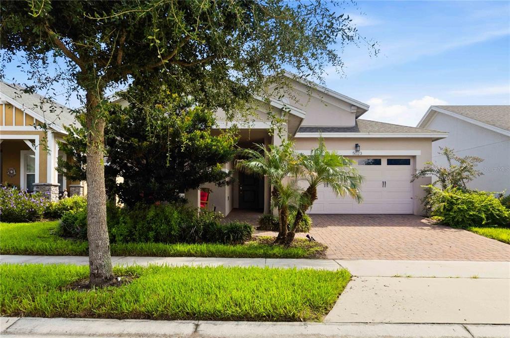 A single-story house with a paved driveway, a two-car garage, and a landscaped front yard — 5023 SUNFALLS AVENUE, ST CLOUD, FL