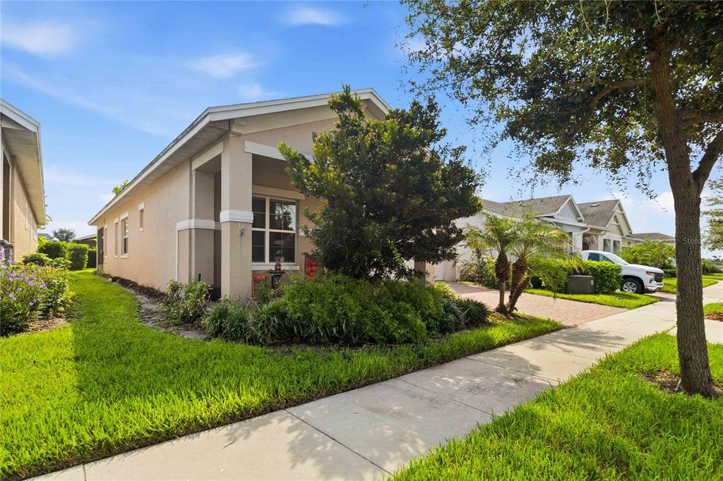 A beige single-story house with a paved driveway and a landscaped front yard — 5023 SUNFALLS AVENUE, ST CLOUD, FL