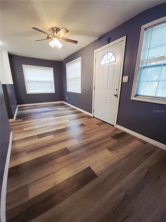 A room with dark purple walls, wood-look flooring, a ceiling fan, and a white door — 3532 38TH AVENUE N, ST PETERSBURG, FL