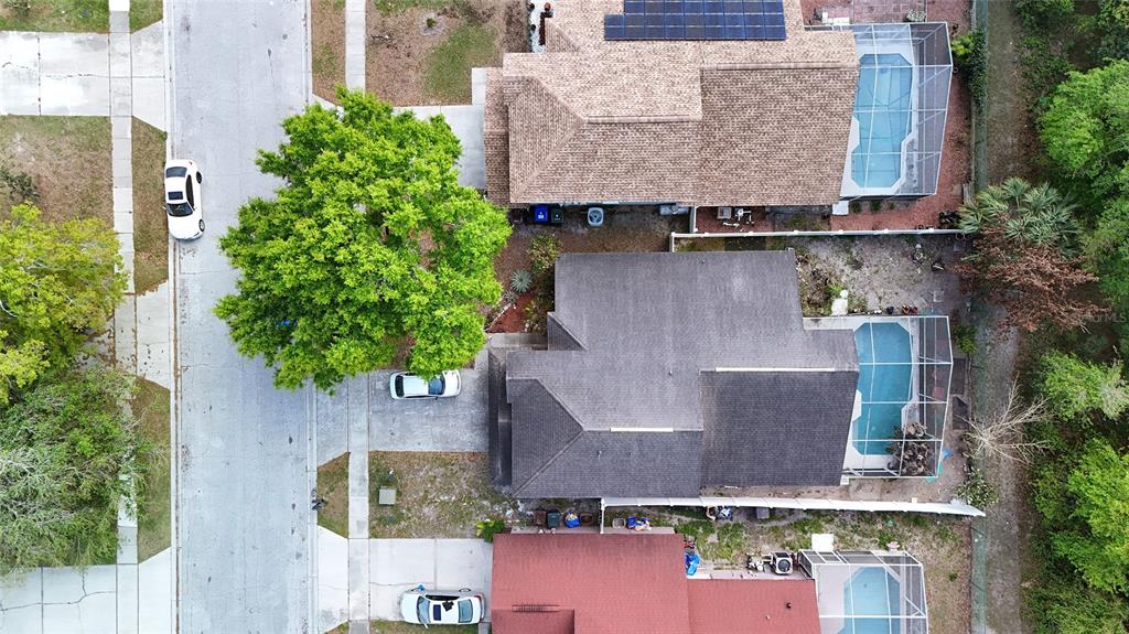 A two-story green house with a two-car garage and a sunset sky in the background — 4381 CREEKSIDE BOULEVARD, KISSIMMEE, FL