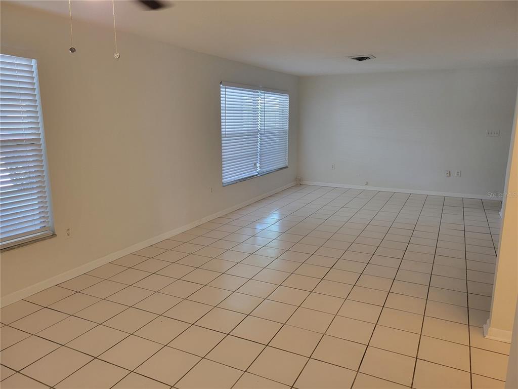 An empty room with white walls, tiled flooring, and two windows with blinds — 1508 N SATURN AVENUE, CLEARWATER, FL