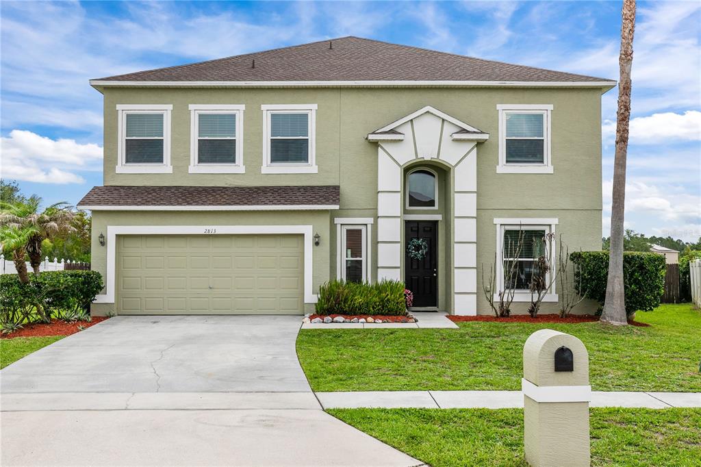 A two-story beige house with a garage containing a vintage truck and a palm tree — 2813 VILLAGE PINE TERRACE, ORLANDO, FL