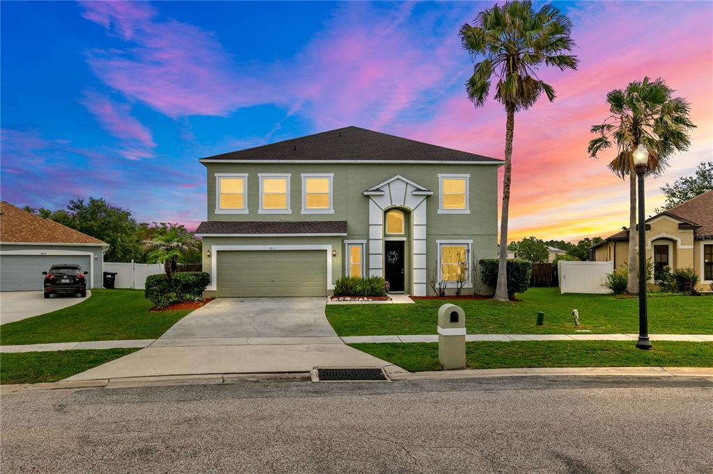 An open-concept living room and kitchen featuring tile floors, leather furniture, and a lake view — 2813 VILLAGE PINE TERRACE, ORLANDO, FL