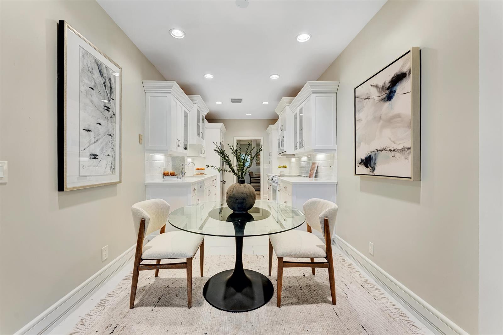 A galley kitchen features white cabinetry, a glass-topped dining table, and two upholstered chairs — 310 Spyglass Way, Jupiter FL 33477, JUPITER, FL