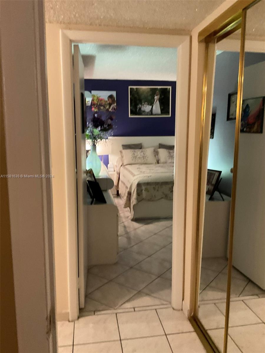 A view through a doorway shows a bedroom with a dark blue accent wall — 4675 W 18th Ct # 502, Hialeah FL 33012, HIALEAH, FL