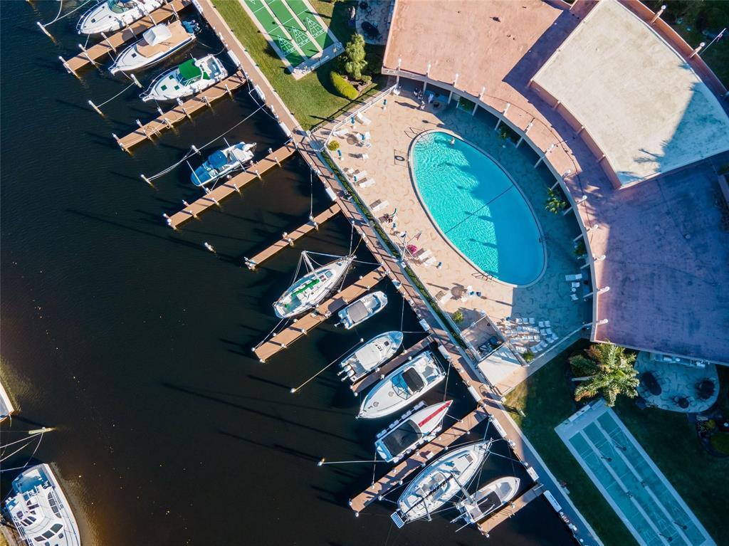 An aerial view shows a marina with docked boats, a swimming pool, and shuffleboard courts — 2731 NE 14th St Causeway NE # 103, Pompano Beach FL 33062, POMPANO BEACH, FL