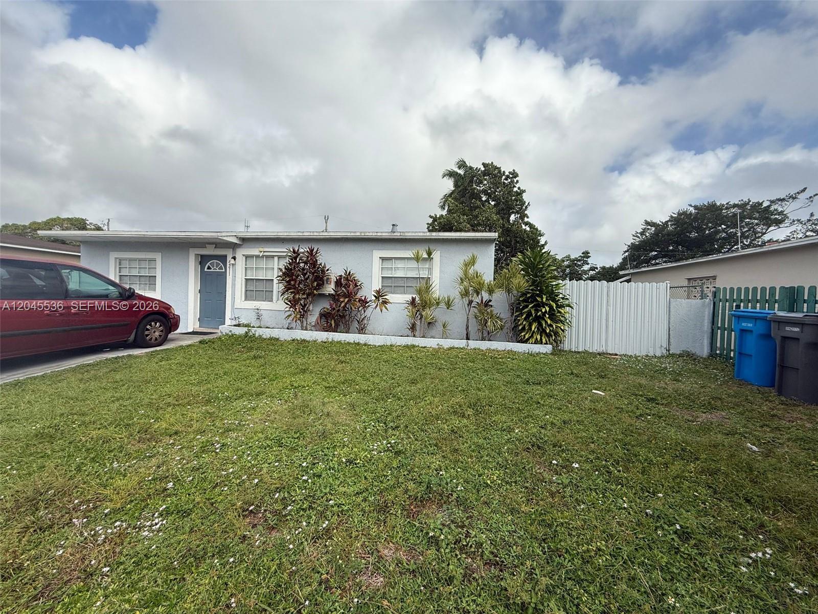 A single-story light blue house with a front lawn and a parked red car — 4211 SW 38th St, West Park FL 33023, WEST PARK, FL