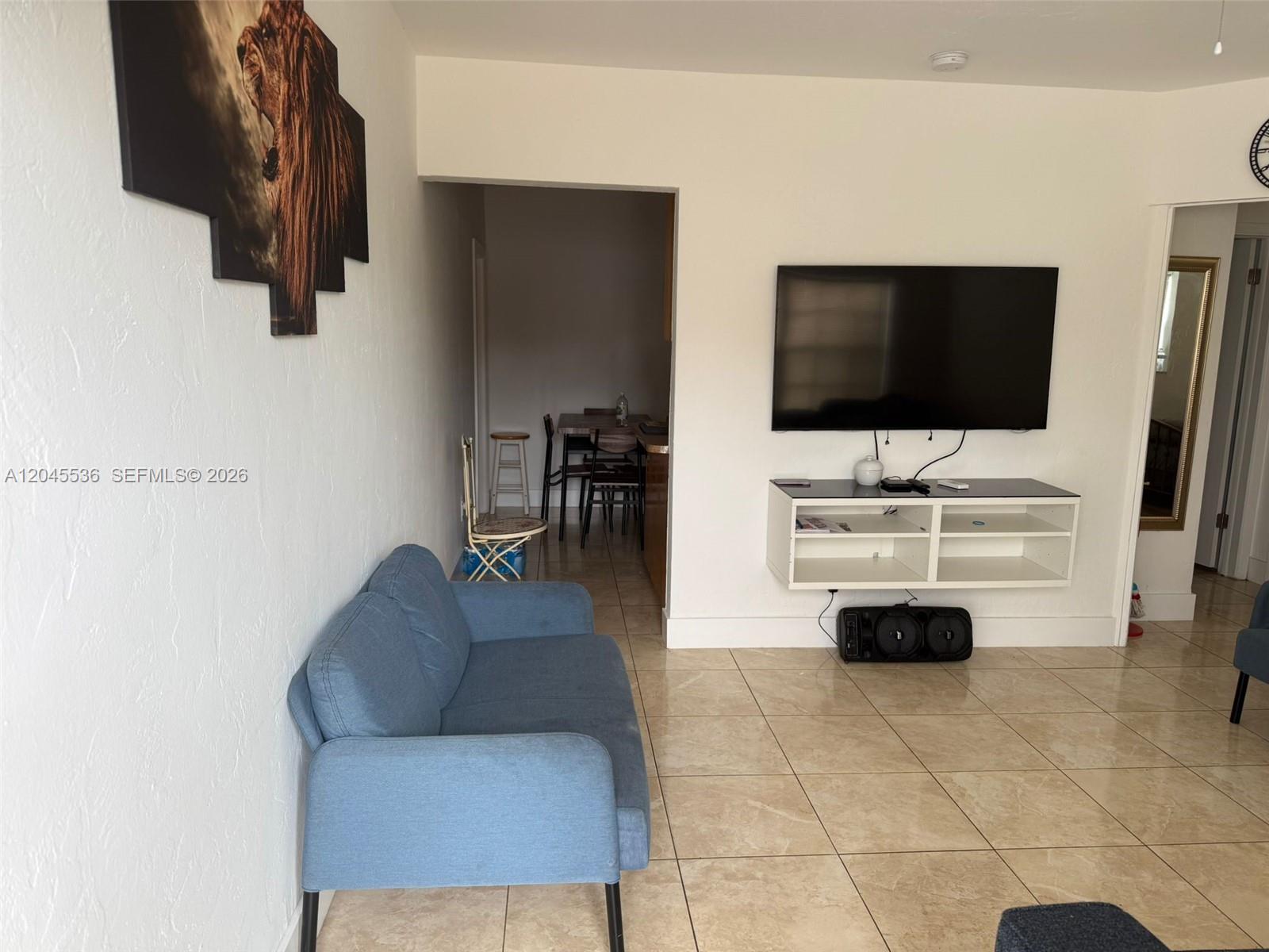 A living room features a blue sofa, a wall-mounted television, and beige tile flooring — 4211 SW 38th St, West Park FL 33023, WEST PARK, FL