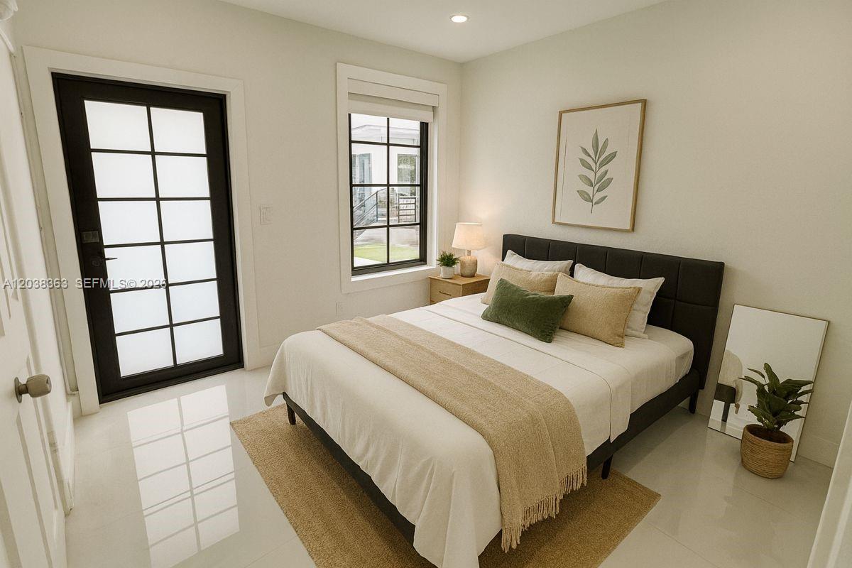 A bedroom features a bed with neutral bedding, a black door, and a window — 733 Michigan Ave # 9, Miami Beach FL 33139, MIAMI BEACH, FL