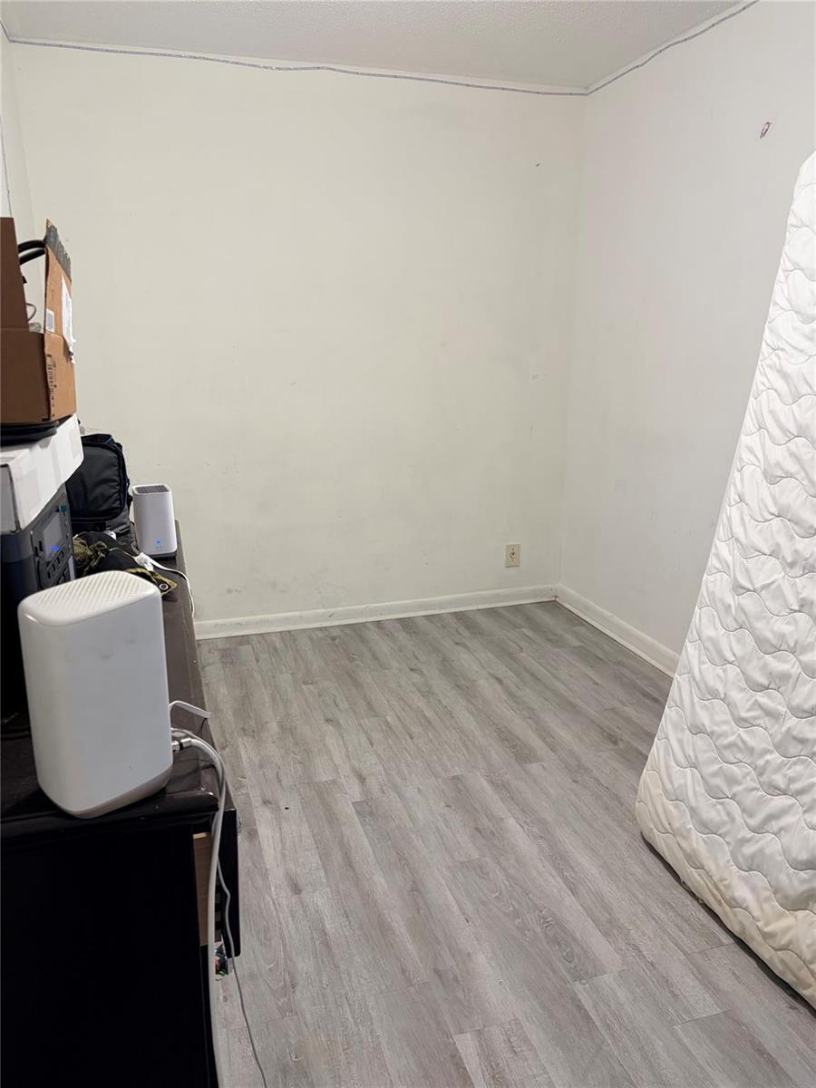 An empty room features white walls, gray wood-look flooring, and a mattress leaning against a wall — 8208 SW 23 # 18B, North Lauderdale FL, NORTH LAUDERDALE, FL