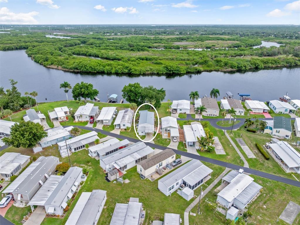 An aerial view shows a mobile home community situated along a riverbank — 8320 RIVERSIDE DRIVE UNIT 99, PUNTA GORDA, FL