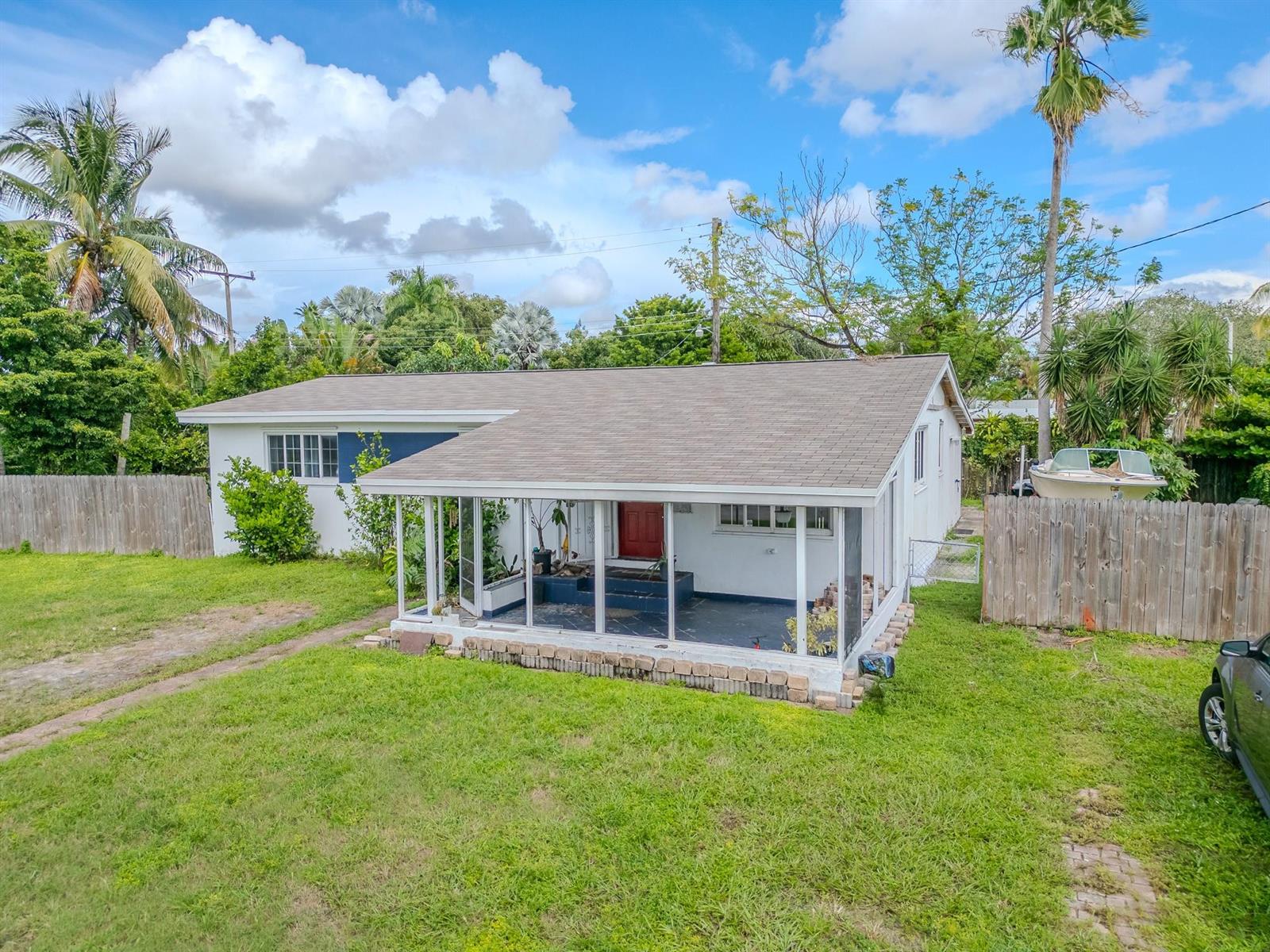A single-story house with a screened-in front porch, white siding, and a red front door — 2011 SW 97th Terrace, Miramar FL 33025, MIRAMAR, FL