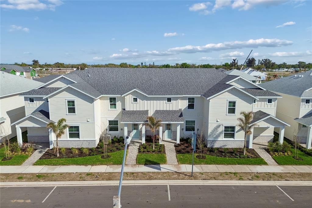 An exterior view of a multi-unit residential building with light siding and a gray roof — 8103 SEAFLOWER PARKWAY, BRADENTON, FL