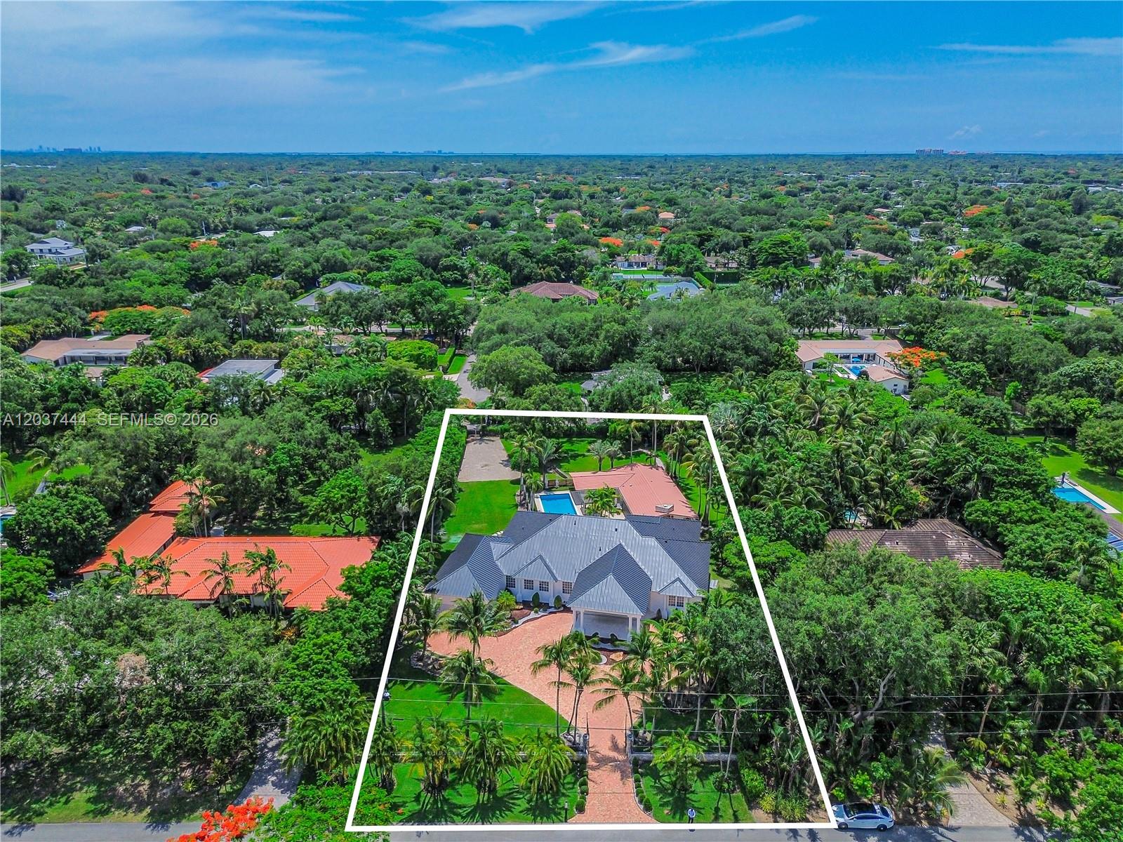 An aerial view shows a large house with a grey roof and pool on a lot — 12201 SW 92nd Ave, Miami FL 33176, MIAMI, FL