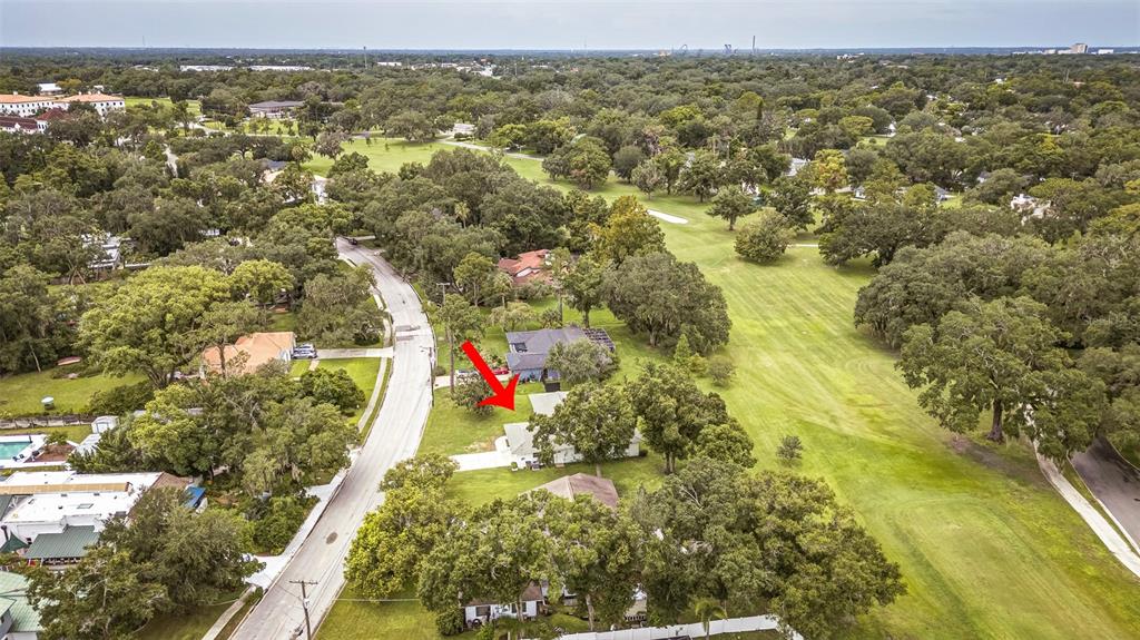 An aerial view shows a residential house with a red arrow pointing toward its roof — 936 N RIVERHILLS DRIVE, TAMPA, FL