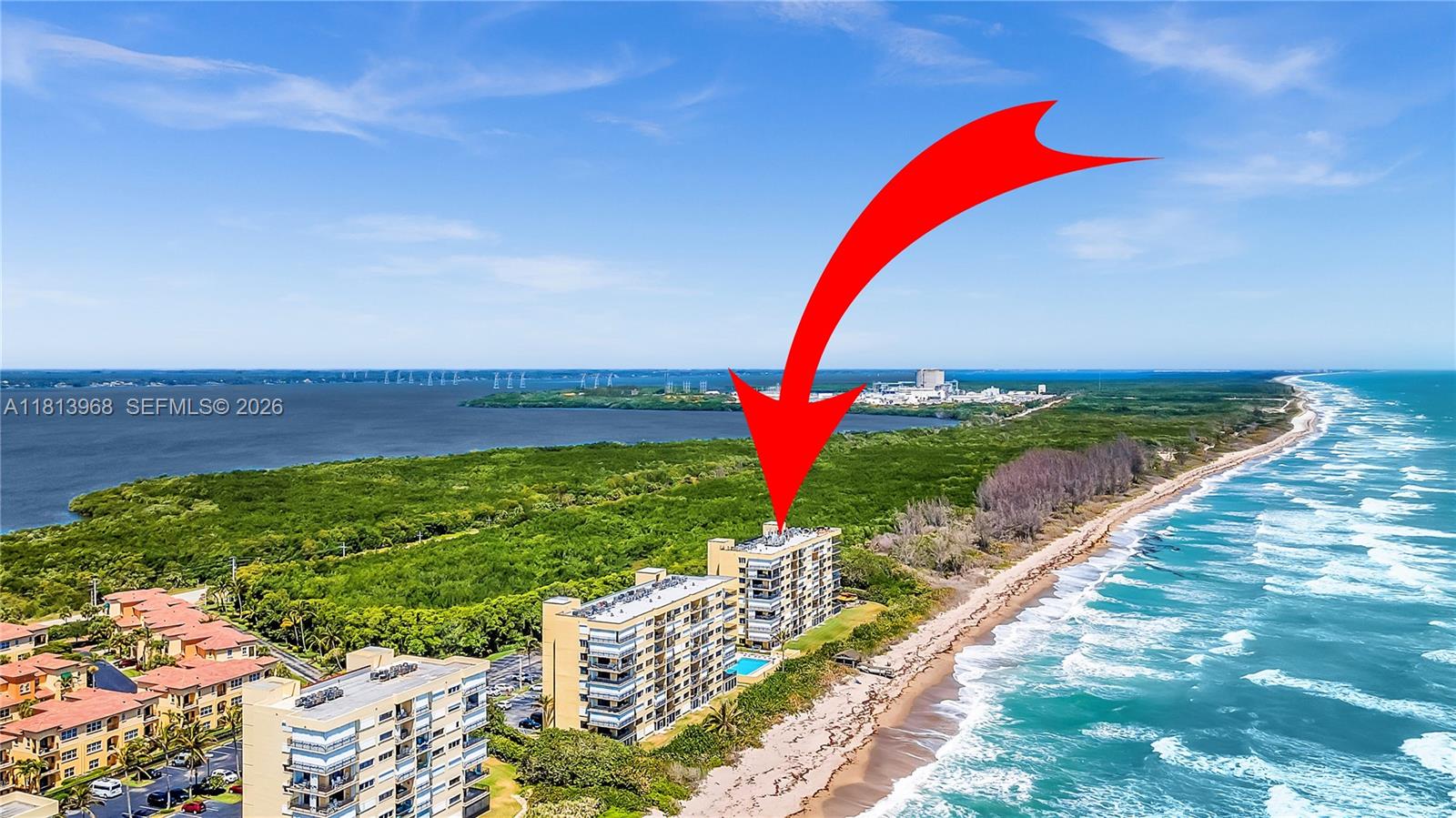 An aerial view shows beachfront apartment buildings situated between the ocean and a bay — 7370 S Ocean Dr # 815, Jensen Beach FL 34957, JENSEN BEACH, FL