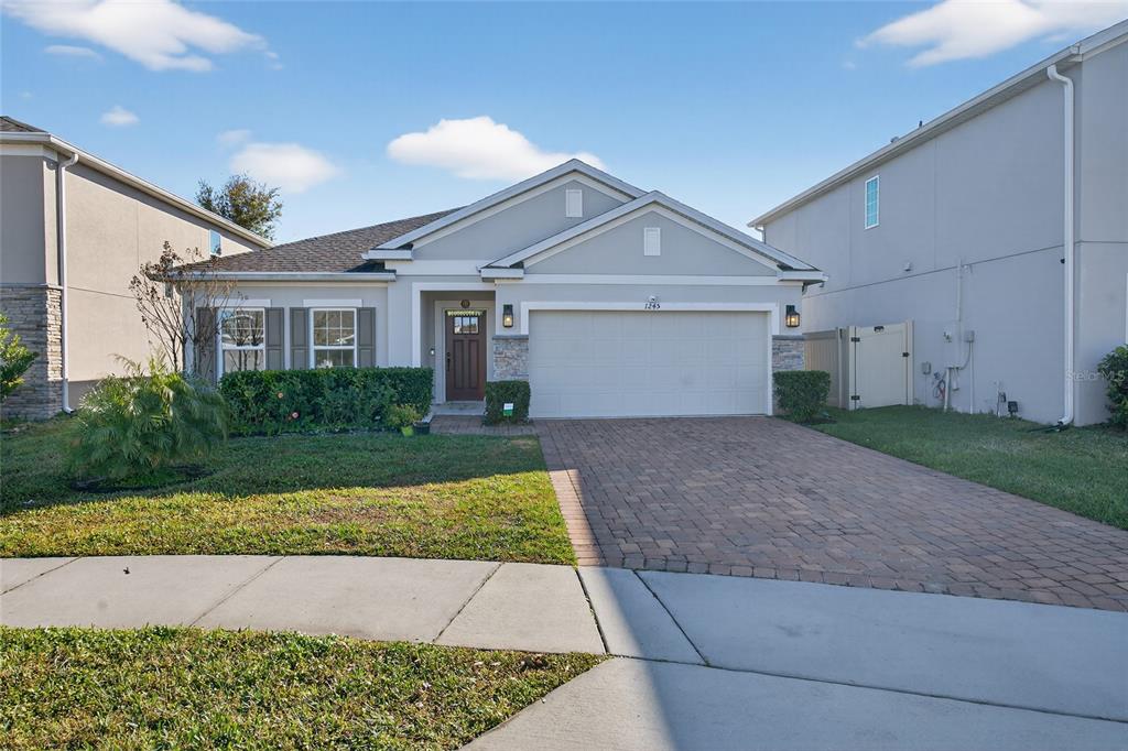 A single-story house with a paved driveway, a two-car garage, and a front lawn — 1245 CELERY OAKS LANE, SANFORD, FL