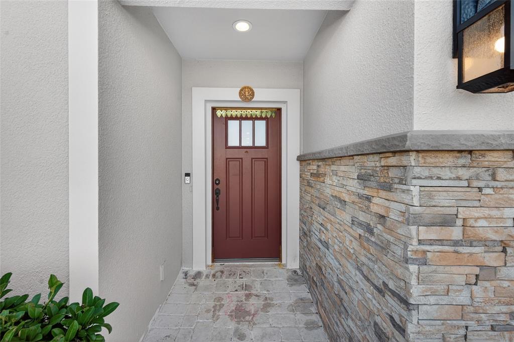 A front entryway features a red door, stone veneer siding, and a paved porch — 1245 CELERY OAKS LANE, SANFORD, FL