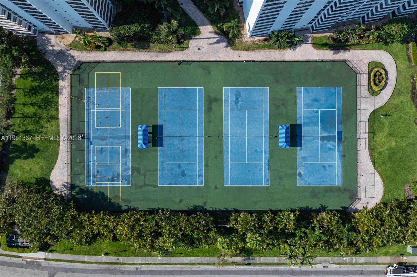 An aerial view shows four tennis courts with blue surfaces and a surrounding green area — 2500 Parkview Dr # 2517, Hallandale Beach FL 33009, HALLANDALE BEACH, FL