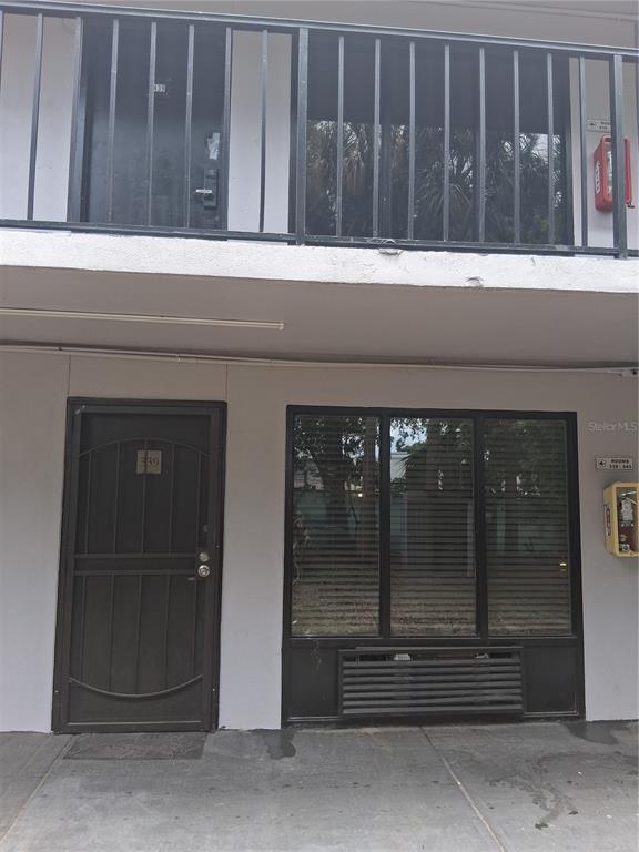 A ground-level hotel room entrance features a dark metal door and a large window — 8421 S ORANGE BLOSSOM TRAIL UNIT 339, ORLANDO, FL