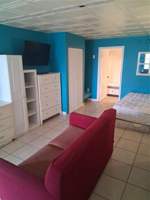 A bedroom with blue walls, tile flooring, a red sofa, and a mattress on the floor — 8421 S ORANGE BLOSSOM TRAIL UNIT 339, ORLANDO, FL