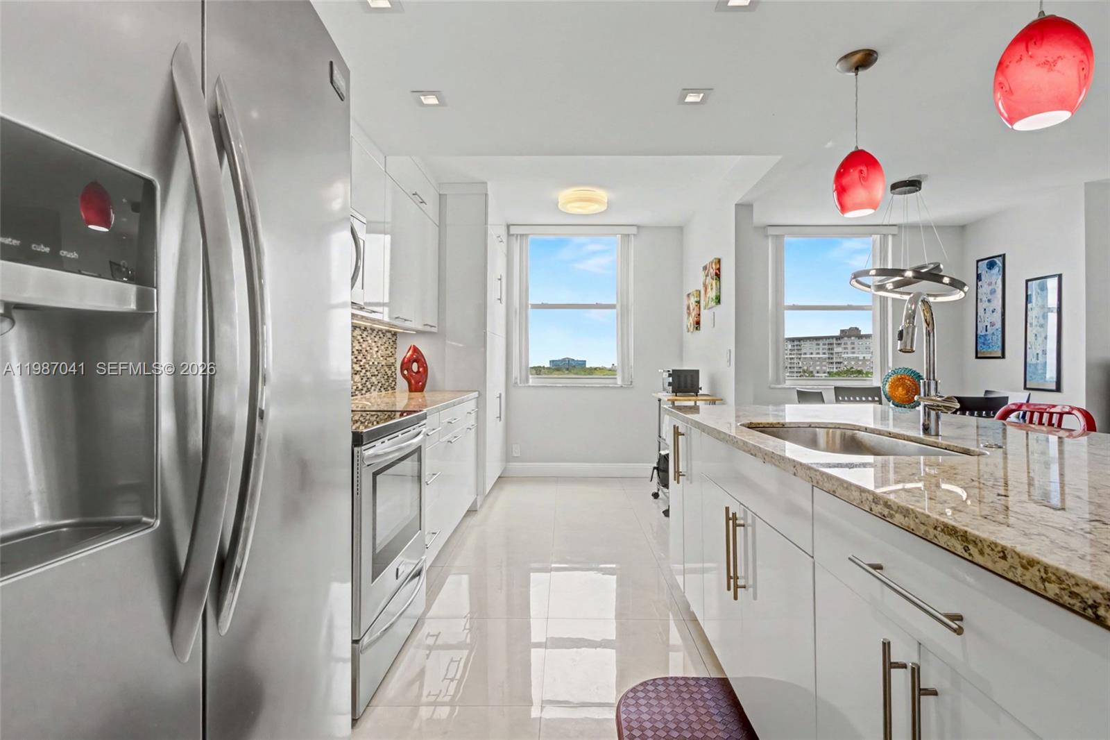 A modern kitchen features white cabinetry, stainless steel appliances, granite countertops, and a central island — 4330 Hillcrest Dr # 619, Hollywood FL 33021, HOLLYWOOD, FL
