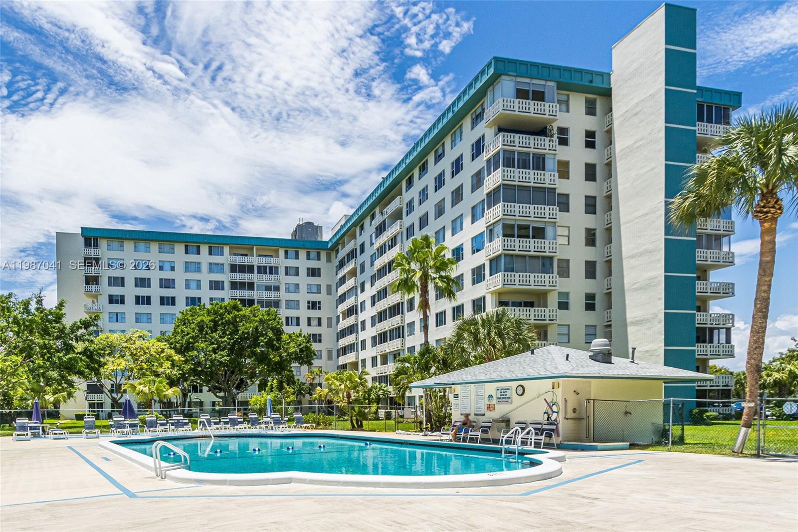 A large apartment building with a swimming pool and palm trees in the foreground — 4330 Hillcrest Dr # 619, Hollywood FL 33021, HOLLYWOOD, FL