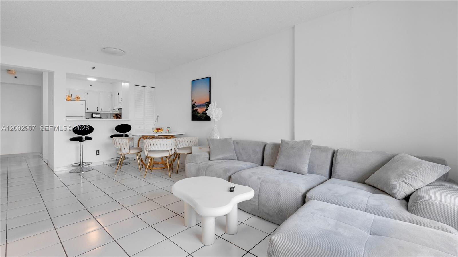 A living room with white tile floors, a grey sectional sofa, and a small dining area — 546 SW 1st St # 603, Miami FL 33130, MIAMI, FL