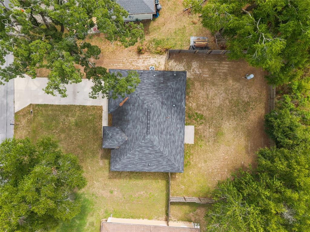 An aerial view shows a house with a dark shingled roof and a large yard — 25 DOGWOOD DRIVE TRAIL, OCALA, FL