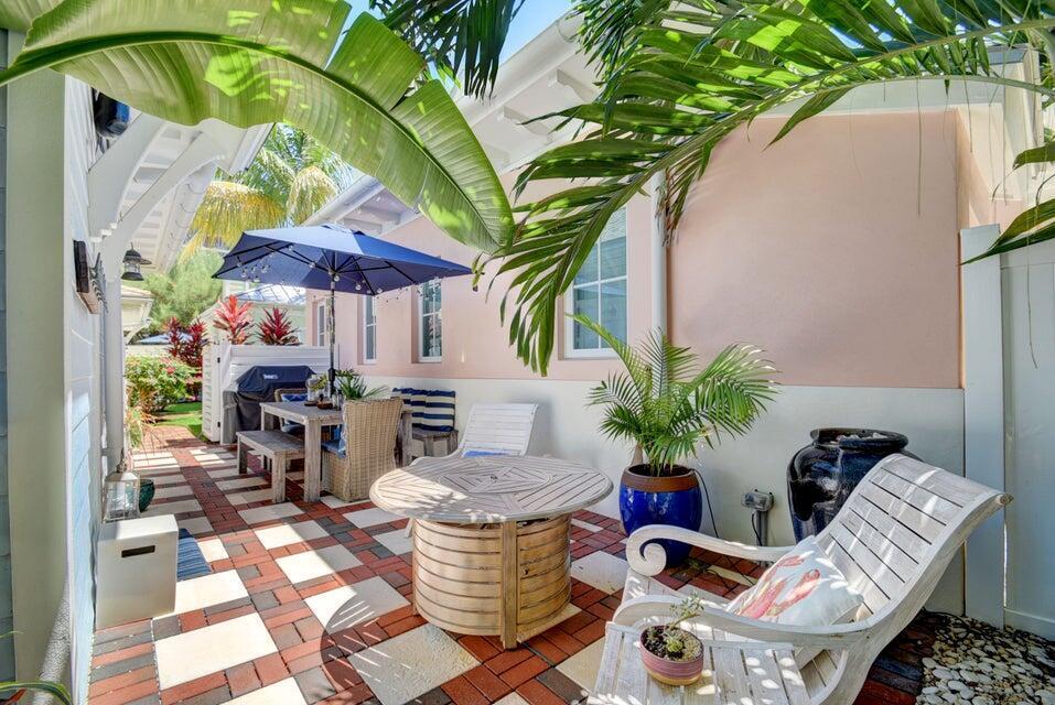 A patio with brick pavers, outdoor furniture, a blue umbrella, and tropical plants — 2225 S Ocean Boulevard # a, Delray Beach FL 33483, DELRAY BEACH, FL