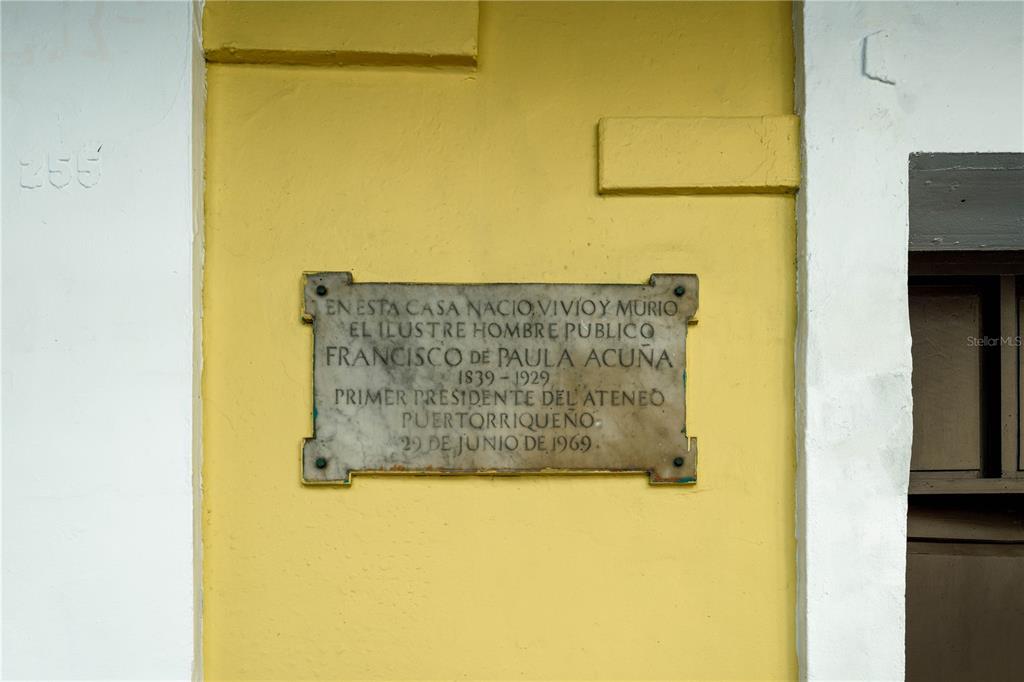 A yellow exterior wall features a commemorative plaque honoring Francisco de Paula Acuña — 255 SAN JUSTO STREET, SAN JUAN, PR