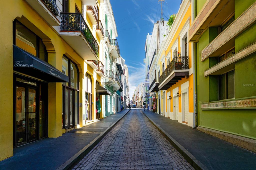 A narrow cobblestone street lined with colorful historic buildings and balconies in Old San Juan — 255 SAN JUSTO STREET, SAN JUAN, PR