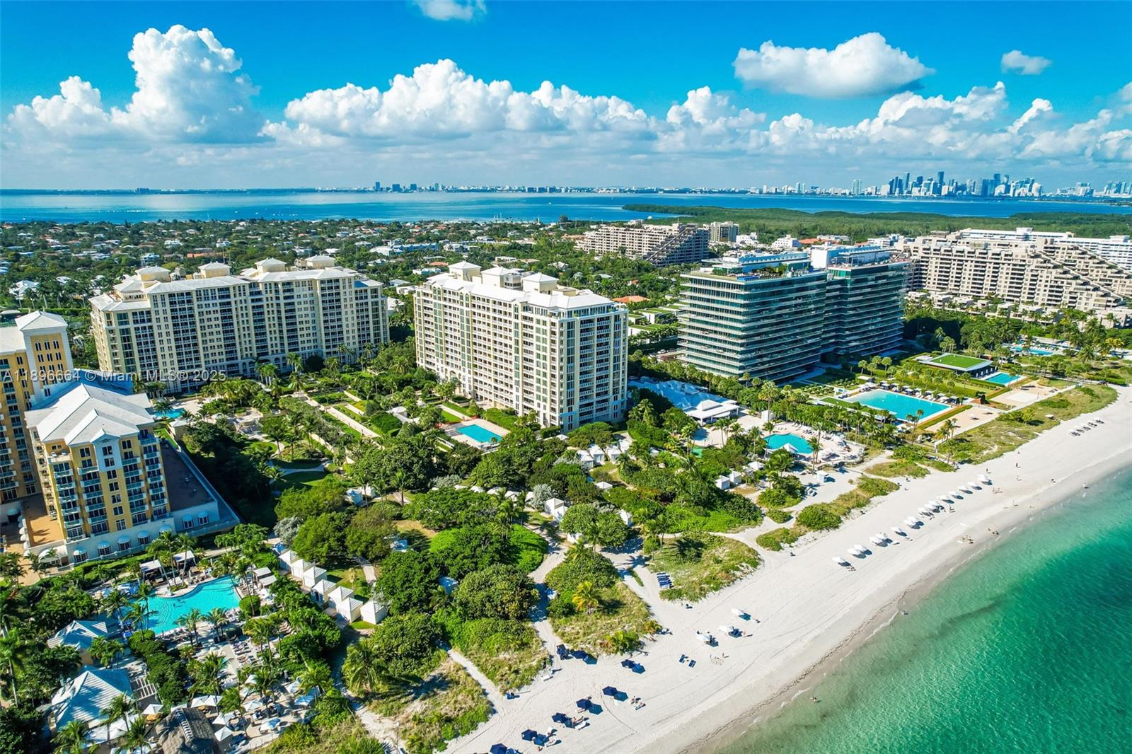 An aerial view of beachfront high-rise residential buildings surrounded by lush landscaping and swimming pools — 445 Grand Bay Dr # 1001, Key Biscayne FL 33149, KEY BISCAYNE, FL